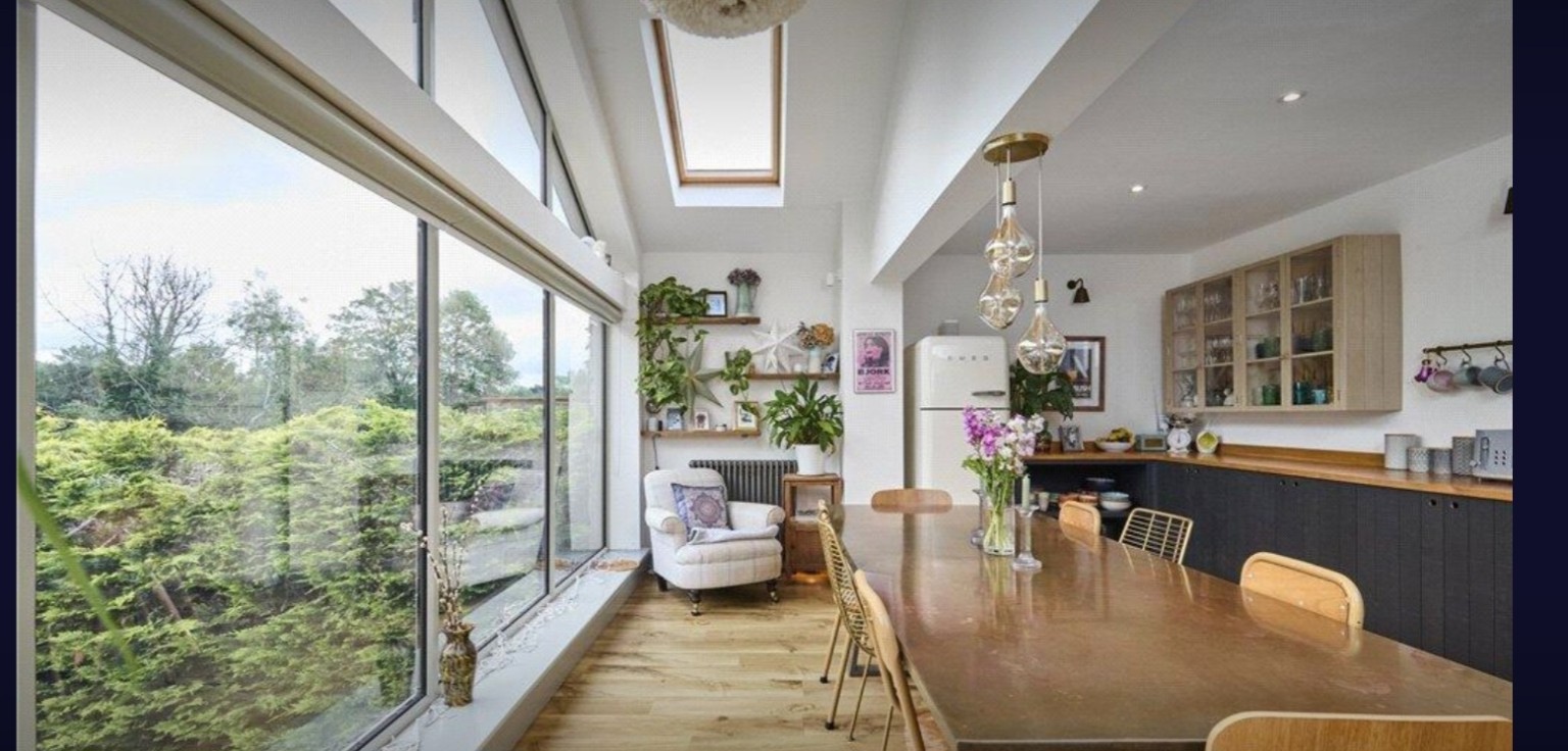 Dining space with rooflight, full-height windows and bespoke cabinetry