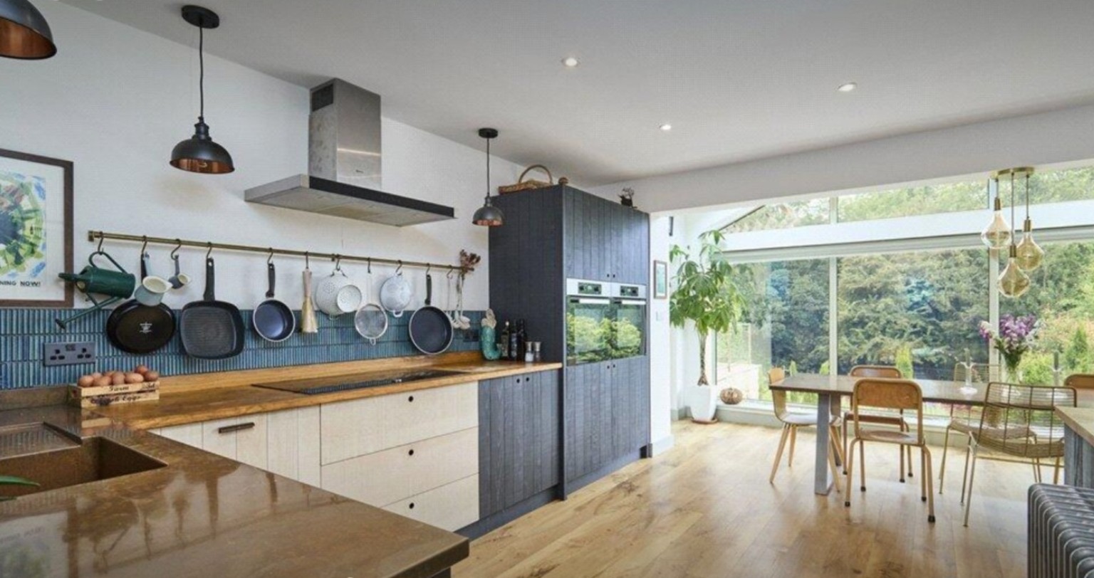 Open-plan bespoke kitchen leading to the glazed dining area